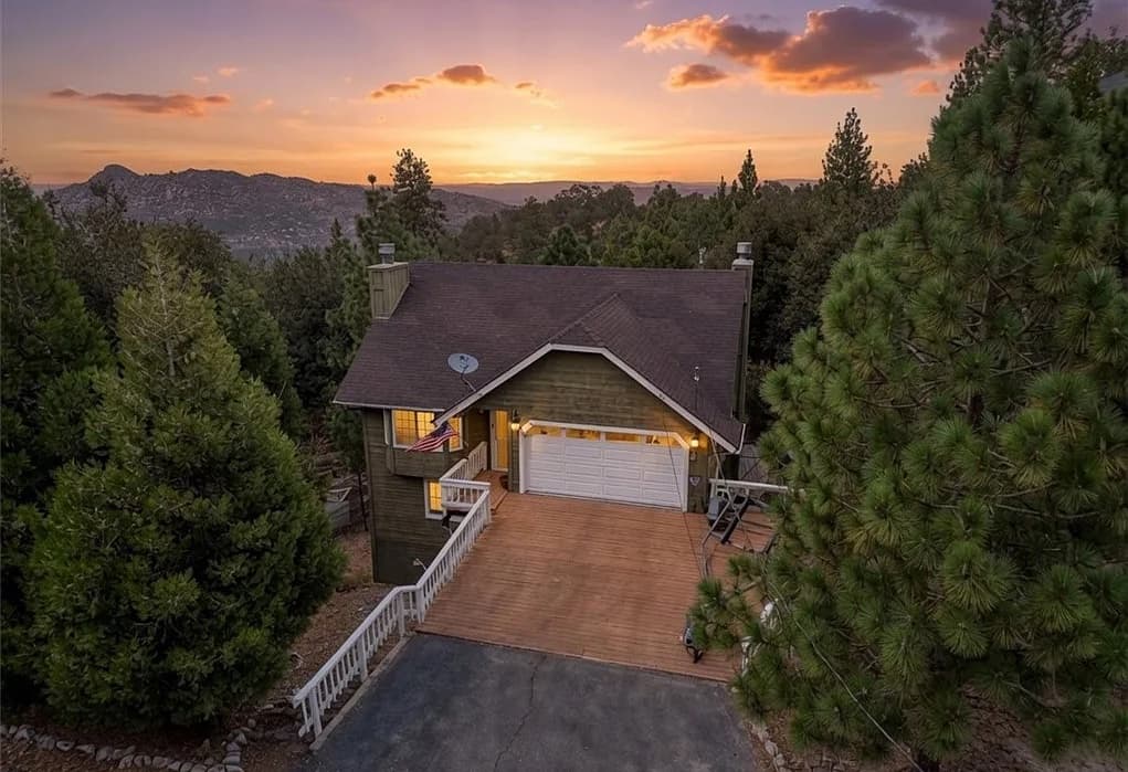 Sunset over a Lake Arrowhead mountain home surrounded by pines
